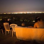 July 12, 2014 – Israeli residents, mostly from Sderot, sit on a hill overlooking the Gaza Strip to watch Israeli bombardment of Gaza. (By Menahem Kahana/AFP/Getty Images)
