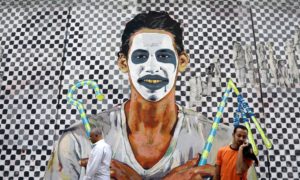 Egyptians walk past graffiti with modern and pharaonic motifs in Mohammed Mahmoud Street near Tahrir Square, Cairo in 2014. The famous wall is being systematically knocked down. Photograph: Hassan Ammar/AP